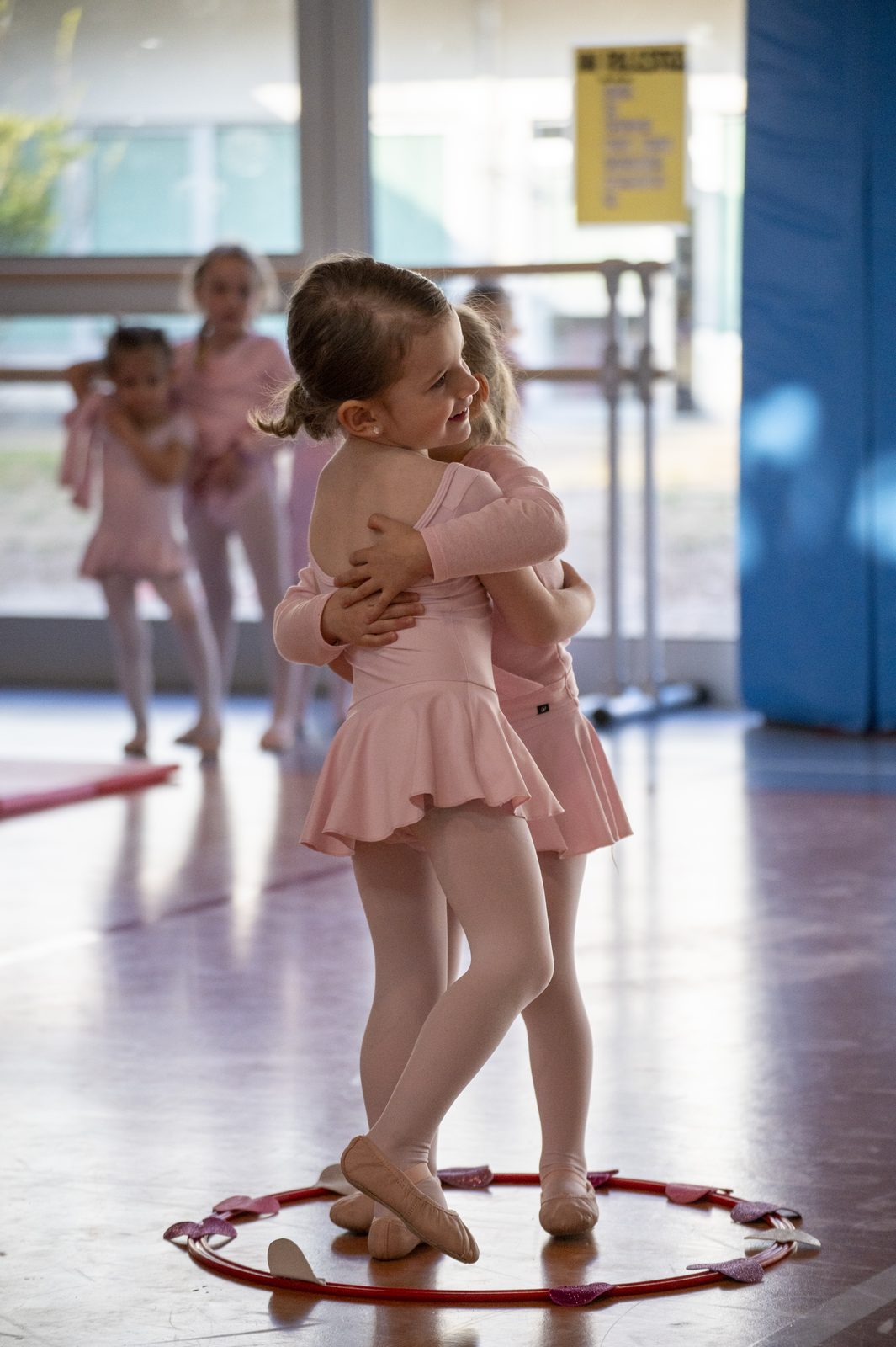 Bambine si abbracciano dentro un cerchio durante la lezione di Gioco Danza